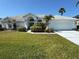 Charming single-story home with well-manicured lawn, lush landscaping and a two car garage on a sunny day at 4228 Presidential Avenue E Cir, Bradenton, FL 34203