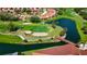 Aerial view of a lush golf course with a bridge, ponds, sand traps, and surrounding residential community at 4228 Presidential Avenue E Cir, Bradenton, FL 34203