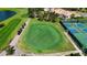 Aerial view of a putting green with golf carts, a community pool, and tennis courts nearby at 4228 Presidential Avenue E Cir, Bradenton, FL 34203