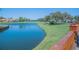 Picturesque view of a tranquil pond with manicured lawns, landscaping, and a wooden railing at 4228 Presidential Avenue E Cir, Bradenton, FL 34203