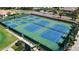 Aerial view of vibrant blue and green tennis and pickleball courts surrounded by lush landscaping at 4228 Presidential Avenue E Cir, Bradenton, FL 34203