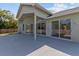 Covered back patio with gray concrete and multiple sliding glass doors that let in lots of light at 426 Village Dr, Tarpon Springs, FL 34689