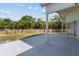 The large gray concrete back patio features a lawn with trees and a wood fence at 426 Village Dr, Tarpon Springs, FL 34689