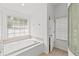 Relaxing soaking tub in bright bathroom with tiled floors and glass block window at 426 Village Dr, Tarpon Springs, FL 34689
