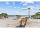 Picturesque sandy beach with a wooden bench, ideal spot for relaxation and enjoying the ocean view at 426 Village Dr, Tarpon Springs, FL 34689