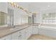 Bright main bathroom with double sinks, soaking tub, and tiled floors at 426 Village Dr, Tarpon Springs, FL 34689