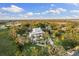 Aerial view of the home with a beautifully landscaped yard and surrounding trees at 450 Bayshore Dr, Terra Ceia, FL 34250