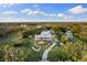 Aerial view showcases grand estate with lush grounds, pool and gardens at 450 Bayshore Dr, Terra Ceia, FL 34250