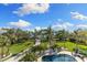Expansive backyard with a pool, lush greenery, and a picturesque driveway at 450 Bayshore Dr, Terra Ceia, FL 34250