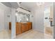 Bathroom featuring wood cabinets, a large mirror, and doorway to an attached room at 450 Bayshore Dr, Terra Ceia, FL 34250