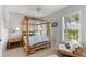 Bedroom with a bamboo four-poster bed and neutral tile flooring near a window at 450 Bayshore Dr, Terra Ceia, FL 34250