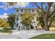 Charming two-story light blue home with white trim and multiple porches overlooking lush landscaping at 450 Bayshore Dr, Terra Ceia, FL 34250