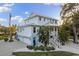 Spacious light blue house with balconies, complemented by lush tropical landscaping and a well-maintained exterior at 450 Bayshore Dr, Terra Ceia, FL 34250