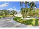 Beautiful front yard with meticulously landscaped beds, lush palm trees and a circular driveway at 450 Bayshore Dr, Terra Ceia, FL 34250