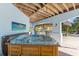 Outdoor hot tub with a thatched roof bar, stainless steel grill, and seating area for entertaining at 450 Bayshore Dr, Terra Ceia, FL 34250