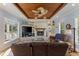 Cozy living room with a stone fireplace, built-in shelves, and a wood-paneled ceiling with fan at 450 Bayshore Dr, Terra Ceia, FL 34250