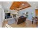 Bright living room features a stone fireplace, wood ceiling, and views to outdoor scenery through multiple windows at 450 Bayshore Dr, Terra Ceia, FL 34250