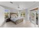 Bright main bedroom with French doors leading to a balcony and tiled floors at 450 Bayshore Dr, Terra Ceia, FL 34250