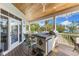 Covered porch with outdoor kitchen and bar, providing a beautiful view of the tropical surroundings and pool at 450 Bayshore Dr, Terra Ceia, FL 34250