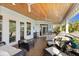 Entertainer's porch with an outdoor kitchen, bar seating, and comfortable lounge area under a wood ceiling at 450 Bayshore Dr, Terra Ceia, FL 34250
