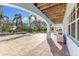 A covered patio area with brick flooring, arched supports, and views of the backyard and pool at 450 Bayshore Dr, Terra Ceia, FL 34250