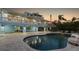 Back exterior view of a home, with a large pool, patio area, and lush landscaping at 450 Bayshore Dr, Terra Ceia, FL 34250