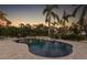 Relaxing backyard with a beautiful pool surrounded by lush landscaping and tall palm trees at 450 Bayshore Dr, Terra Ceia, FL 34250
