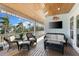 Relaxing covered porch with wicker furniture, ceiling fan, and a mounted TV for outdoor entertainment at 450 Bayshore Dr, Terra Ceia, FL 34250