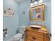 Powder room with a decorative mirror and wooden vanity with a vessel sink at 450 Bayshore Dr, Terra Ceia, FL 34250