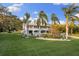 Beautifully landscaped yard with lush green grass and tropical landscaping at 450 Bayshore Dr, Terra Ceia, FL 34250