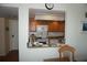 Cozy kitchen with white appliances, oak cabinets, and a pass-through to the adjacent living area at 4900 Brittany S Dr # 1706, St Petersburg, FL 33715