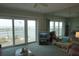 Bright living room featuring sliding glass doors, waterfront views, neutral decor, and comfortable seating at 4900 Brittany S Dr # 1706, St Petersburg, FL 33715
