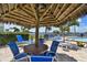 Relaxing poolside patio with lounge chairs, thatch umbrella, and views of the water at 4900 Brittany S Dr # 1706, St Petersburg, FL 33715