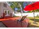 Backyard has a red wooden deck with lounge chairs, a red patio umbrella, and some mature trees at 505 27Th N Ave, St Petersburg, FL 33704