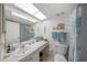 Clean bathroom featuring a vanity, well-lit mirror, tiled floor, and a shower with coordinated blue and white accents at 5080 Locust Ne St # 321, St Petersburg, FL 33703