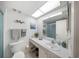 Well-lit bathroom with a large mirror, white countertop, gray towels, and a shower with glass doors at 5080 Locust Ne St # 321, St Petersburg, FL 33703
