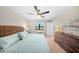 Bedroom with a comfy bed, ceiling fan, large window, and a view into a hallway with stylish decor and ample storage at 5080 Locust Ne St # 321, St Petersburg, FL 33703