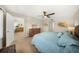 Comfortable bedroom with a ceiling fan, warm lighting, a cozy bed, and a connecting hallway featuring artwork and ample storage at 5080 Locust Ne St # 321, St Petersburg, FL 33703