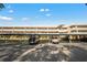 Exterior of a condominium building with covered parking on a sunny day, ample parking spaces, and well-maintained landscaping at 5080 Locust Ne St # 321, St Petersburg, FL 33703