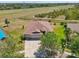 Aerial view of a well-maintained home with a three-car garage and lush landscaping in a quiet neighborhood at 627 Washita Stone Dr, Ruskin, FL 33570