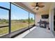 The screened patio includes a ceiling fan, grill, and television for enjoyable outdoor living at 627 Washita Stone Dr, Ruskin, FL 33570