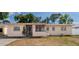 Charming single-story home with a screened porch and well-maintained landscaping and beige exterior at 6414 Larmon St, Tampa, FL 33634