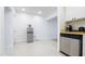 Bright kitchen area with stainless steel dishwasher, half fridge, and access to another room at 6414 Larmon St, Tampa, FL 33634