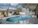 Fenced-in pool in screened lanai featuring ladders and railing, with lounge area and outdoor kitchen at 6414 Larmon St, Tampa, FL 33634