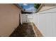 Fenced-in side yard with a narrow concrete path between the house and the white fence at 6414 Larmon St, Tampa, FL 33634
