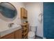 Stylish bathroom with a modern vanity, round mirror, and blue tiled shower at 7006 N Duncan Ave, Tampa, FL 33604