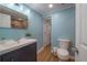 Well-lit bathroom featuring a vanity, toilet, and light blue walls, creating a clean and refreshing atmosphere at 7006 N Duncan Ave, Tampa, FL 33604