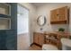 Stylish bathroom featuring a round mirror, modern vanity, and blue tiled wall accents at 7006 N Duncan Ave, Tampa, FL 33604
