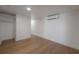 Spacious bedroom features wood floors, an air conditioning unit, and a closet space for convenient storage at 7006 N Duncan Ave, Tampa, FL 33604