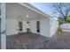 A covered carport featuring a brick paver floor and access doors into the home at 7006 N Duncan Ave, Tampa, FL 33604